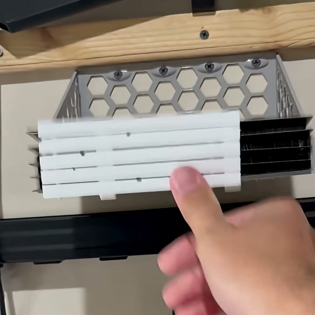3D printed honeycomb build plate holder mounted under a shelf, loaded with Bambu Lab A1 mini build plates