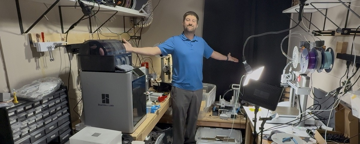 Cam in the PluggedIn3D print room — printers, filament rack, and six machines running